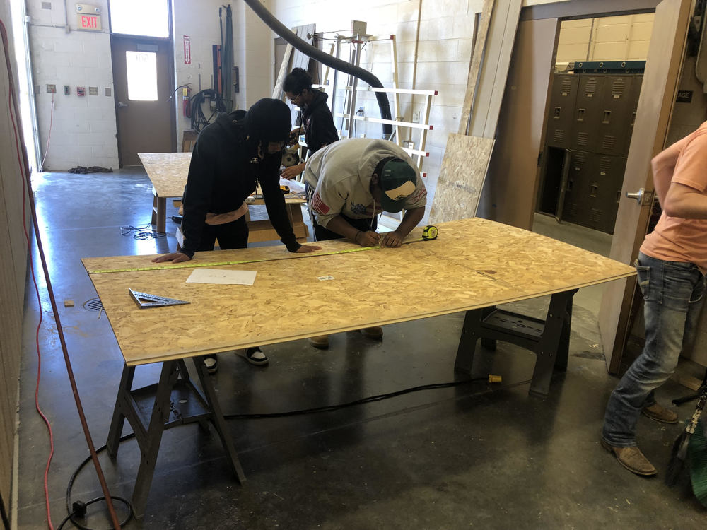 Two students work together at the Career and Technology Center on a construction project.