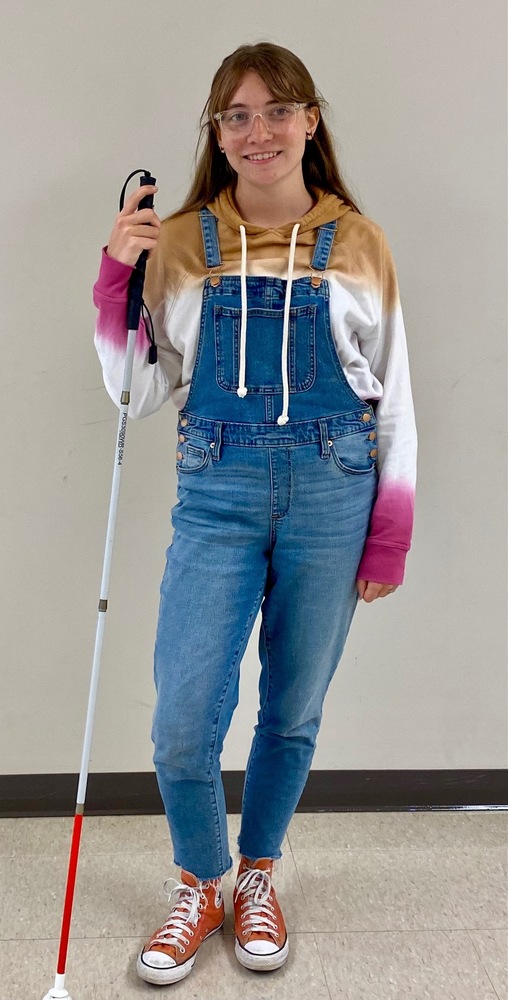 Addie is pictured with her white cane with a red bottom