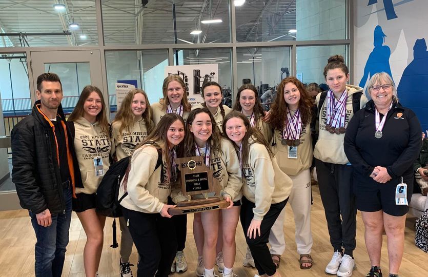 The girls swimming team is pictured with their state runner-up trophy from the 2022 season.