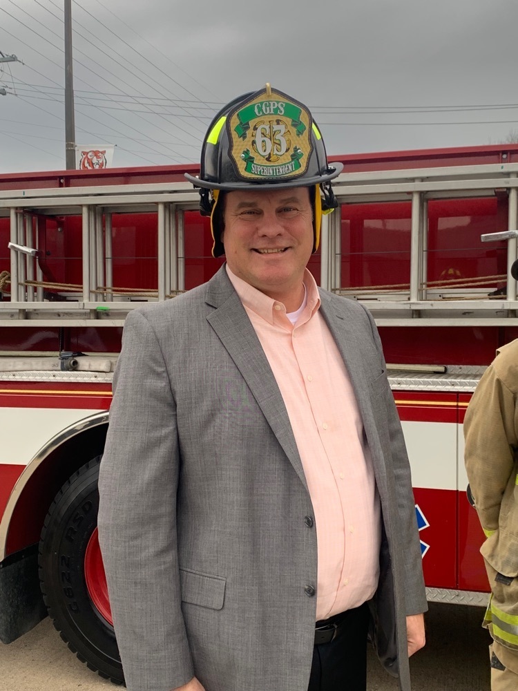 Dr. Glass smiles as he sports his new fire hat