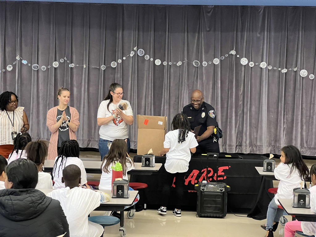 Officer Atlas congratulates a student for graduating from the DARE program.