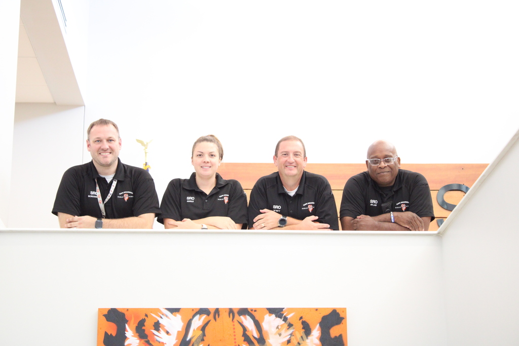 Four school resource officers pose and smile for a picture