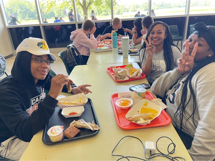 a group of students smile for the camera at the lunch table